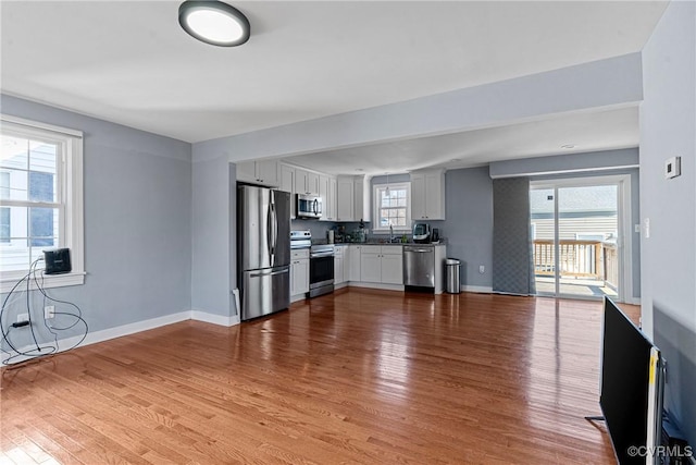 kitchen featuring hardwood / wood-style flooring, white cabinets, and appliances with stainless steel finishes