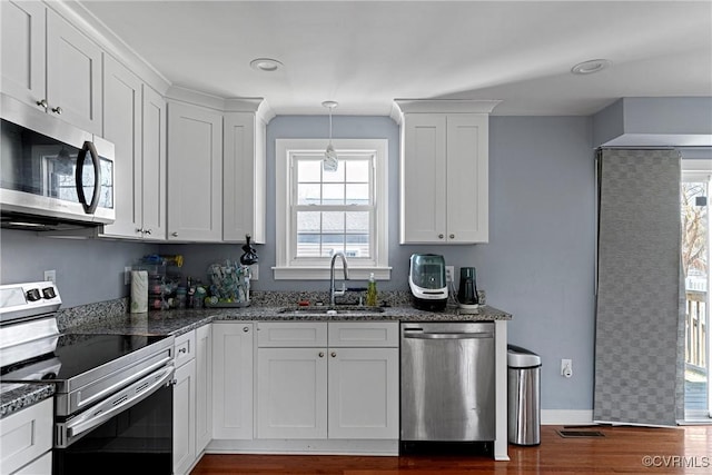 kitchen with dark stone counters, sink, white cabinets, and stainless steel appliances