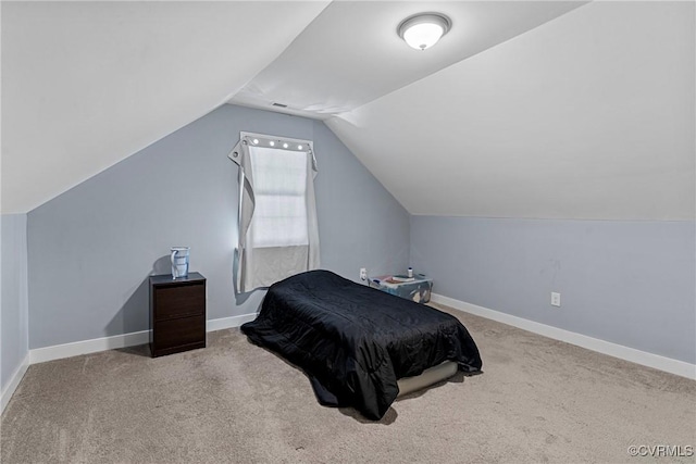 carpeted bedroom with lofted ceiling