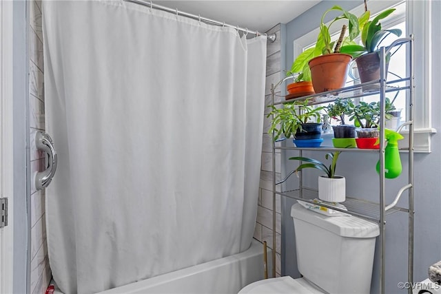 bathroom with shower / bath combo and toilet