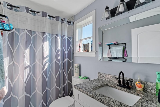 bathroom with a shower with shower curtain, vanity, and toilet