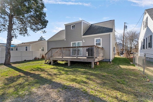 rear view of property with a yard and a wooden deck