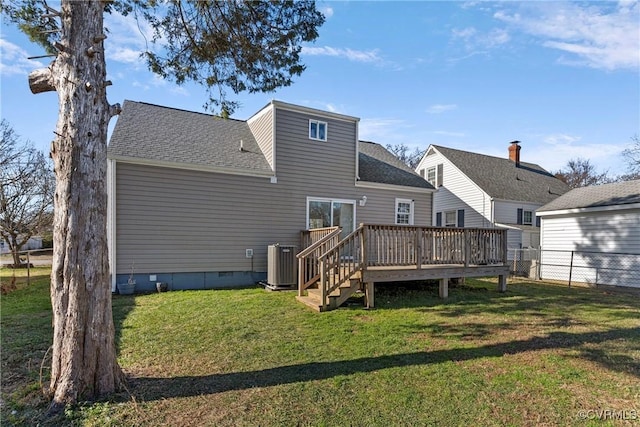 rear view of property featuring central air condition unit, a wooden deck, and a yard