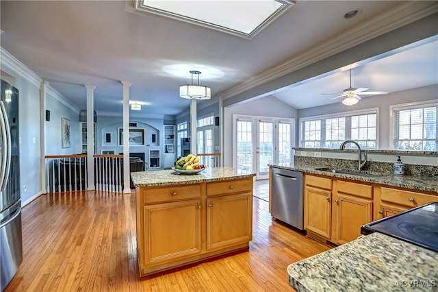 kitchen featuring stainless steel dishwasher, ceiling fan, sink, a center island, and hanging light fixtures