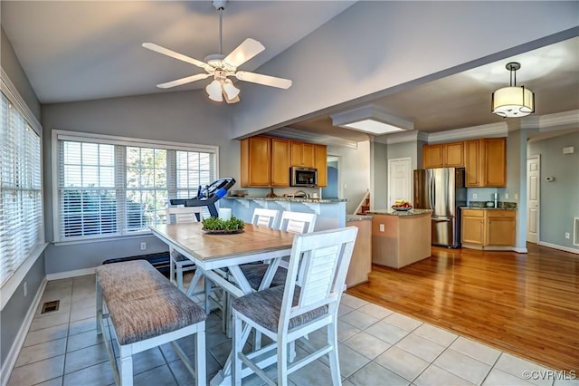 tiled dining area featuring ceiling fan and lofted ceiling