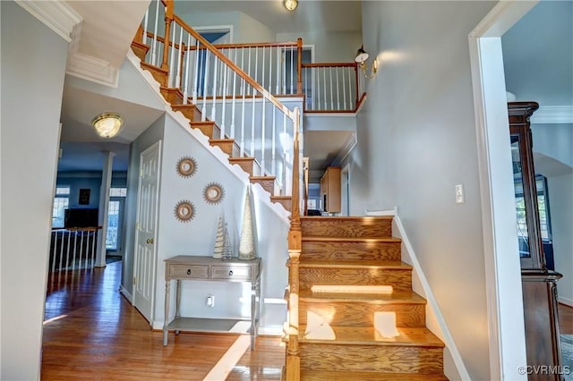 stairs featuring hardwood / wood-style flooring and ornamental molding