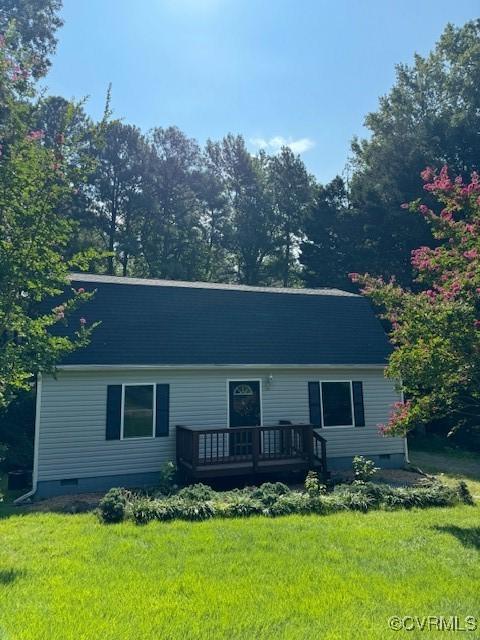 single story home featuring a deck and a front yard