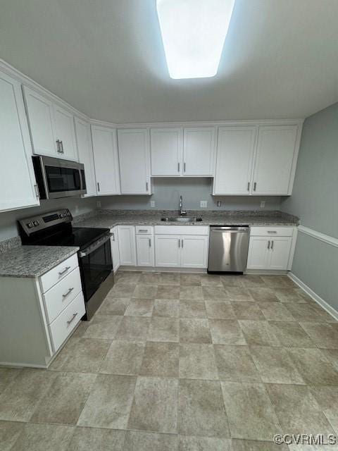 kitchen with white cabinets, stone countertops, sink, and stainless steel appliances