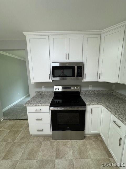 kitchen with white cabinetry, ornamental molding, light stone counters, and appliances with stainless steel finishes