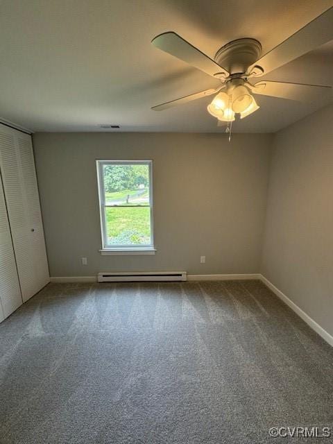 spare room featuring carpet flooring, ceiling fan, and a baseboard heating unit