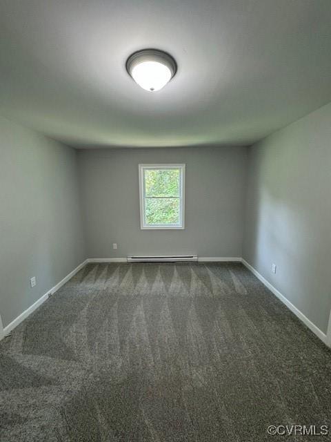 carpeted empty room featuring a baseboard radiator