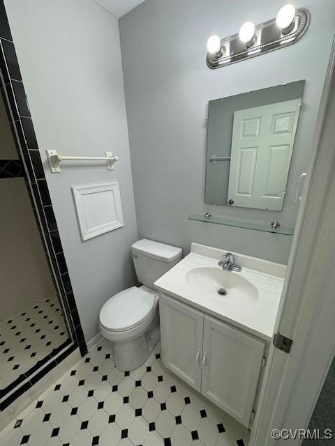 bathroom with toilet, vanity, and walk in shower