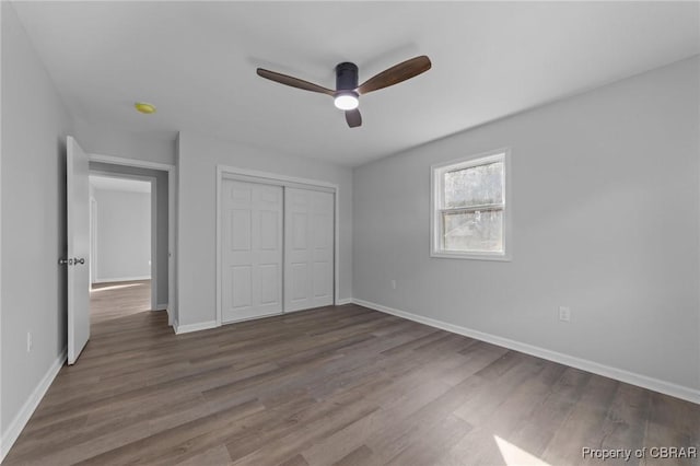 unfurnished bedroom with ceiling fan, a closet, and dark hardwood / wood-style floors