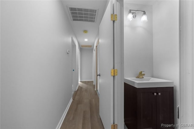 corridor featuring hardwood / wood-style flooring and sink