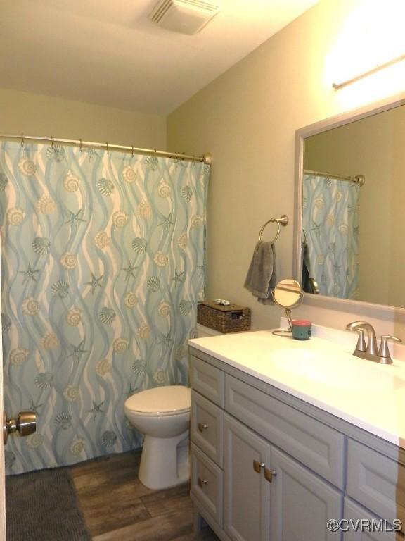 bathroom with vanity, hardwood / wood-style floors, and toilet