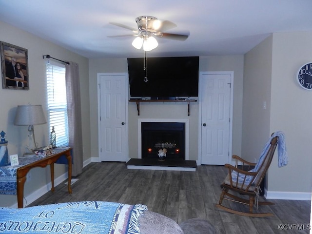 living room with ceiling fan and dark hardwood / wood-style flooring