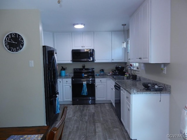 kitchen with pendant lighting, sink, white cabinets, black appliances, and dark wood-type flooring