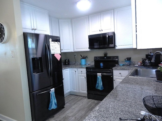 kitchen with white cabinetry, light wood-type flooring, sink, and black appliances