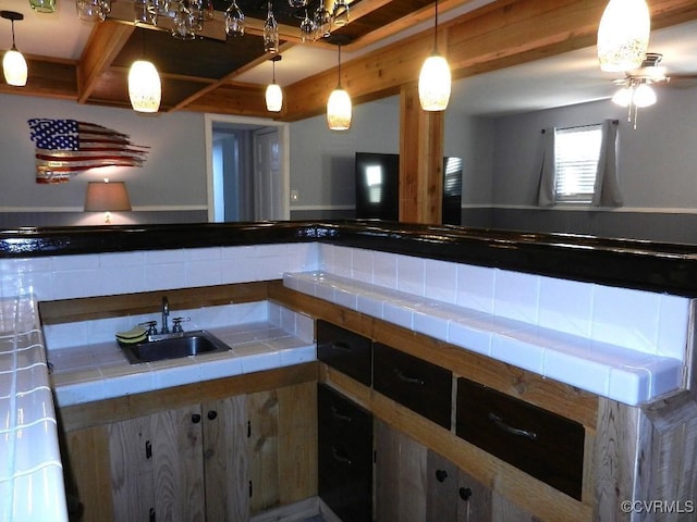 interior space featuring hanging light fixtures, sink, and tile countertops