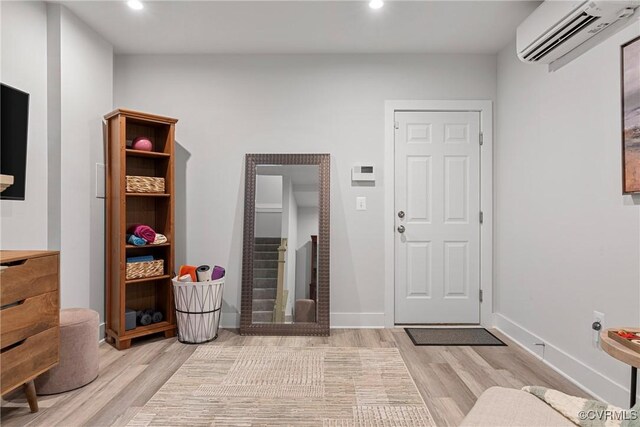 entryway featuring light hardwood / wood-style floors and an AC wall unit