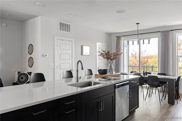 kitchen featuring pendant lighting, dishwasher, sink, and a wealth of natural light