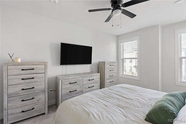 carpeted bedroom featuring multiple windows and ceiling fan