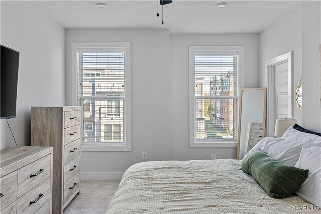 carpeted bedroom featuring multiple windows