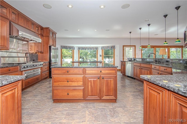 kitchen with pendant lighting, stainless steel appliances, and dark stone counters