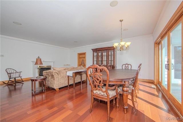 dining space featuring crown molding, an inviting chandelier, a healthy amount of sunlight, and hardwood / wood-style flooring