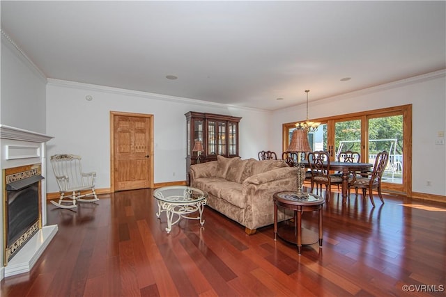 living room with dark hardwood / wood-style flooring, an inviting chandelier, and ornamental molding