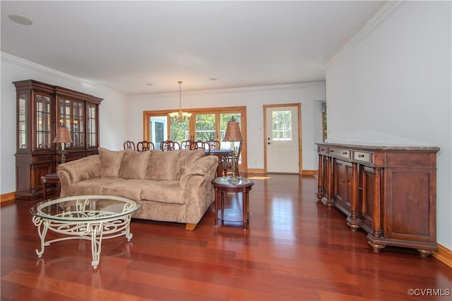 living room with an inviting chandelier, dark hardwood / wood-style floors, and ornamental molding