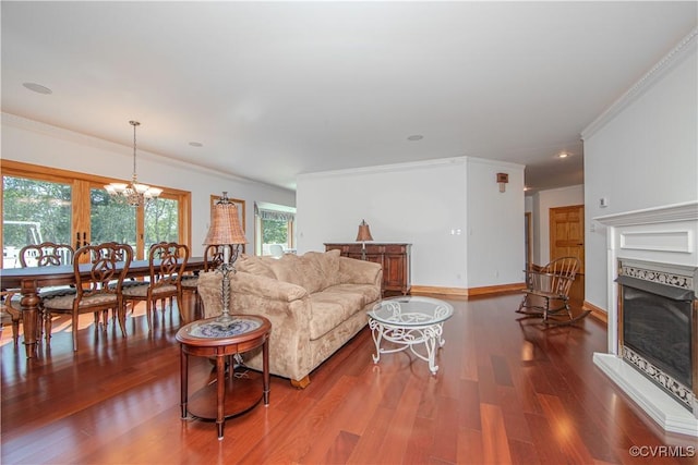 living room with a premium fireplace, an inviting chandelier, hardwood / wood-style flooring, and ornamental molding