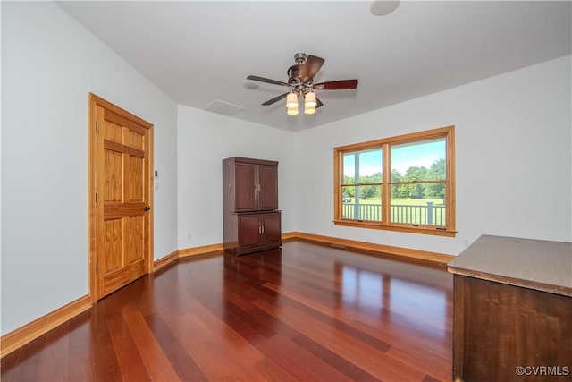 empty room with ceiling fan and dark hardwood / wood-style flooring