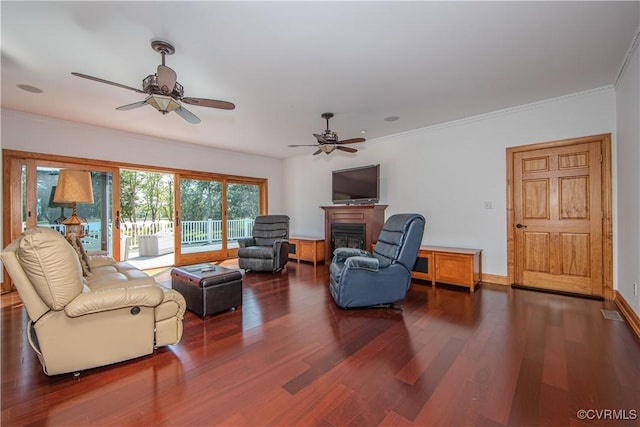 living room with crown molding, ceiling fan, and dark hardwood / wood-style floors