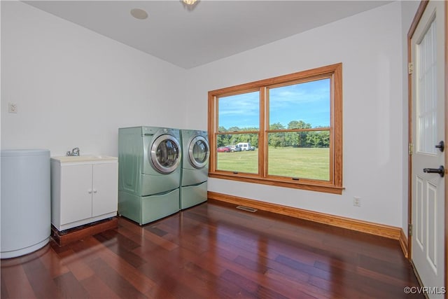 clothes washing area featuring cabinets, dark hardwood / wood-style flooring, washer and dryer, and sink