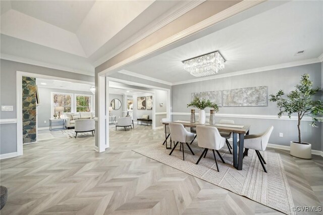 dining space featuring a notable chandelier, ornamental molding, and light parquet flooring