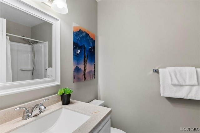 bathroom featuring vanity, toilet, and walk in shower