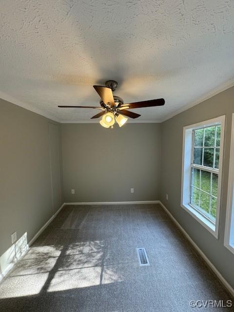 carpeted empty room with ceiling fan, ornamental molding, and a textured ceiling