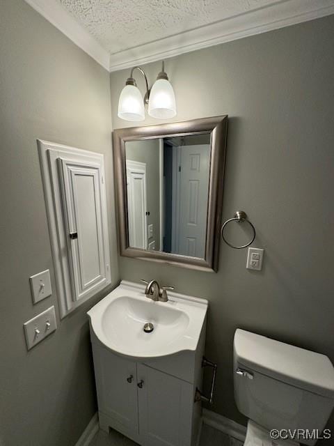 bathroom with vanity, a textured ceiling, toilet, and ornamental molding