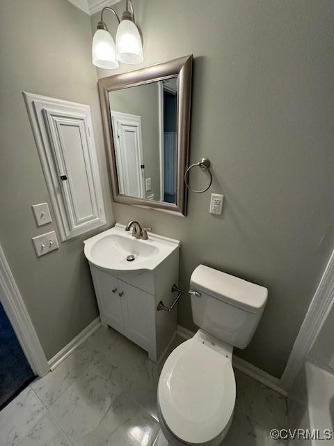 bathroom featuring vanity, toilet, crown molding, and a washtub