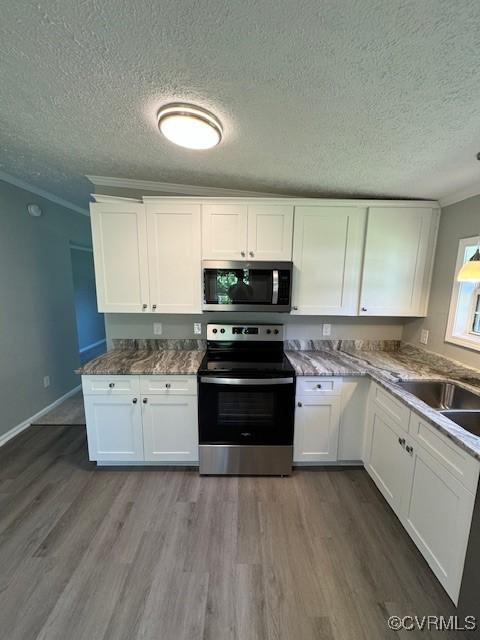 kitchen featuring stainless steel appliances, white cabinetry, crown molding, and sink