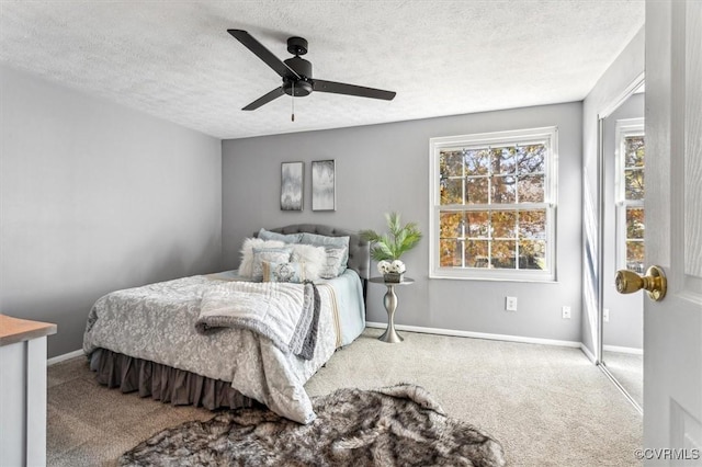 bedroom featuring a textured ceiling, carpet floors, and ceiling fan