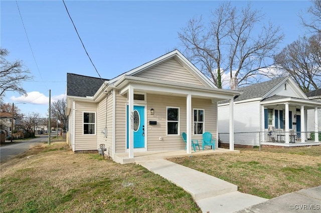 bungalow-style house featuring covered porch and a front yard