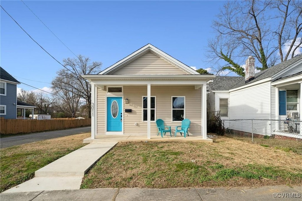 bungalow with covered porch and a front lawn