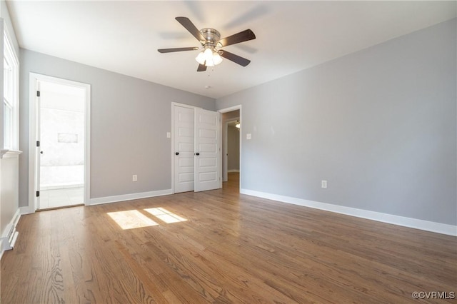 unfurnished bedroom with hardwood / wood-style floors, ceiling fan, and connected bathroom