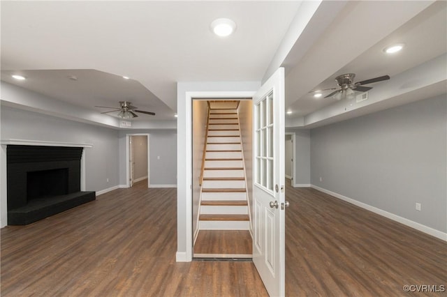 unfurnished living room featuring ceiling fan and dark hardwood / wood-style floors