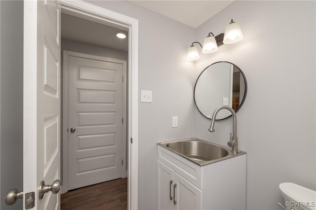 bathroom with hardwood / wood-style floors, vanity, and toilet