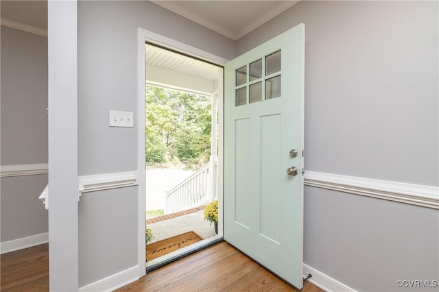 doorway to outside with hardwood / wood-style floors and crown molding