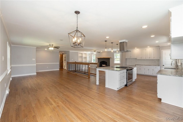 kitchen with white cabinets, a kitchen island, island exhaust hood, and stainless steel range