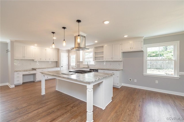 kitchen featuring a center island, exhaust hood, dark hardwood / wood-style flooring, a kitchen bar, and white cabinetry